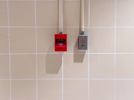 Fire alarm switch on the background of a tile wall,press the button to activate sound in emergency...