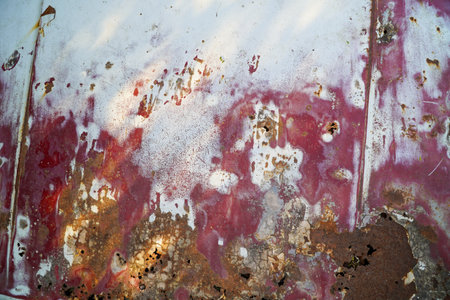Red car hood rusty metal texture with peeling paint. Abstract grunge background for design.の写真素材