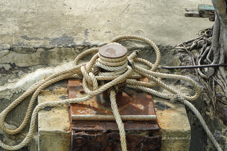 Rope tied to a bollard on a concrete wall,mooring rope and bollard