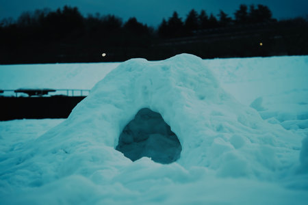 Small handmade snow cave in winter field