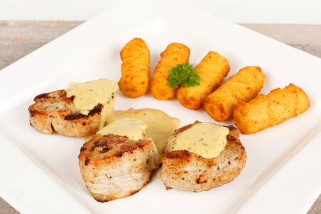 pork fillet with potato croquettes and mustard sauceの写真素材