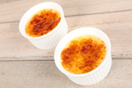 Creme brulee in a bowl on a boardの写真素材