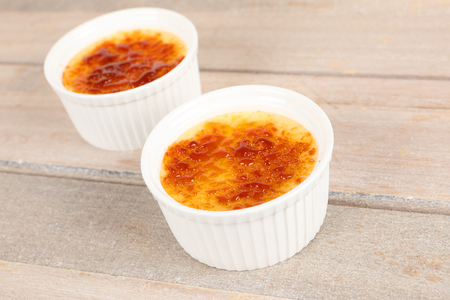 Creme brulee in a bowl on a boardの写真素材