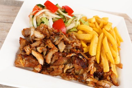 Chicken doner on a plate with fries and saladの写真素材