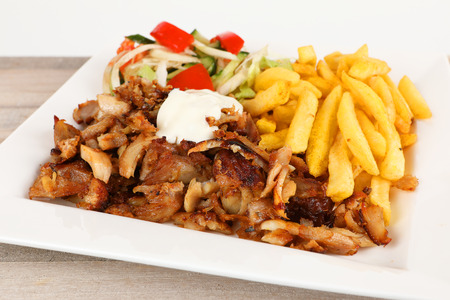 Chicken doner on a plate with fries and saladの写真素材