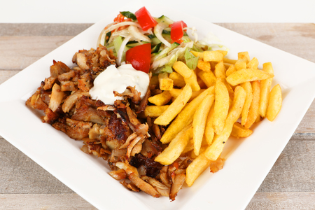 Chicken doner on a plate with fries and saladの写真素材