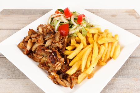 Chicken doner on a plate with fries and saladの写真素材