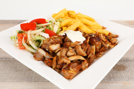 Chicken doner on a plate with fries and saladの写真素材