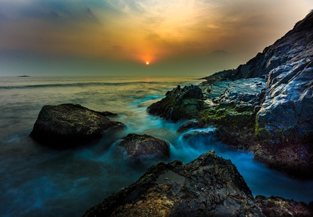 sunset by the rocky beachの写真素材