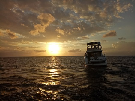A speedboat on the ocean at sunriseの写真素材