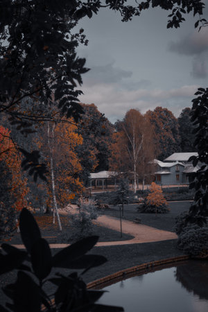 Scenic autumn park view with a house near the lake, captured from above in moody tones.の写真素材