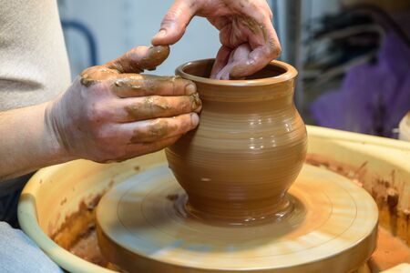 potter makes a pot of clay, working on the potter's wheel.の写真素材
