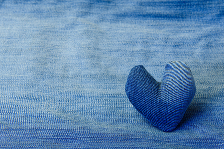 Denim heart lies on a denim background.の写真素材