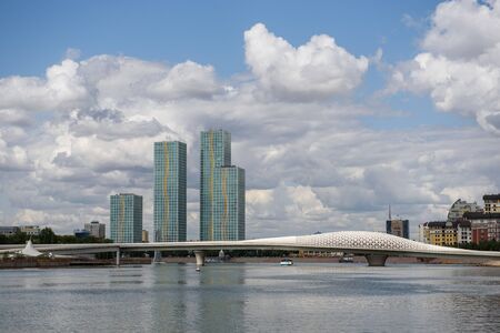 Kazakhstan, Nur Sultan, August 2019. Skyscrapers and a pedestrian bridge, clouds run in the sky,...