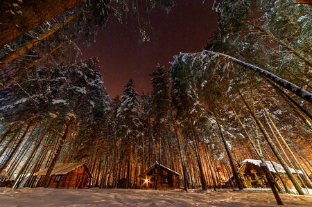 Hut in the woods on a winter Christmas night.の写真素材