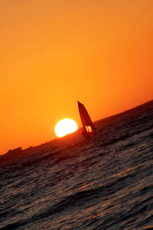 sun going down with wind surferの写真素材
