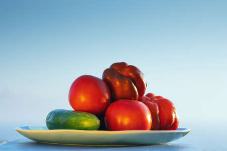 Fresh red tomatoes and cucumber on summer sunset background. Mediterranean summer concept. Space for text. Copy space.の写真素材