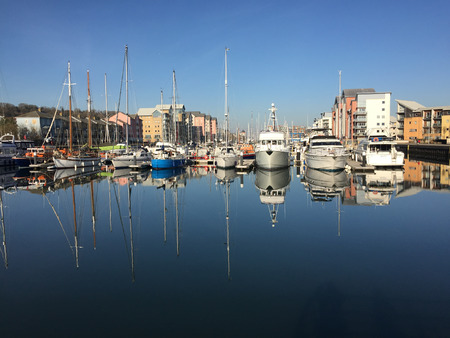 Marina yachts and cruisers reflected in still watersの写真素材