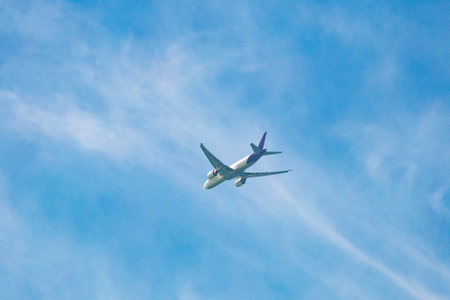 his photo captures a white airplane flying in the azure sky