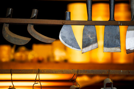 a series of traditional cutting tools displayed on a rackの写真素材