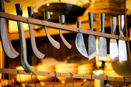 a series of traditional cutting tools displayed on a rack