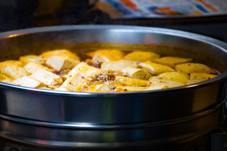 a street food stall where freshly prepared spicy stinky tofu is on displayの写真素材