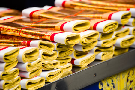 stacks of golden Joss papers arranged neatly on a table for religious ceremonies and offerings