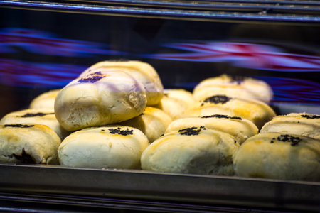 a collection of freshly baked Chinese sesame cakes behind a glass caseの写真素材