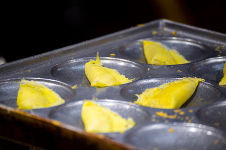 golden handmade egg rolls are neatly arranged on an iron plate