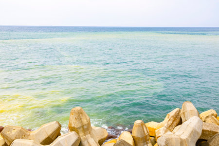 The seawater displays two distinctly different colors, a clear boundary between yellowish-brown and turquoise blueの写真素材