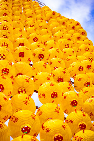 Countless yellow lanterns are densely suspended in the airの写真素材