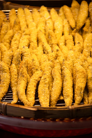 a large pile of deep-fried small fish on a metal grateの写真素材