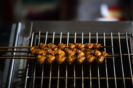 a large pile of grilled chicken butt skewers neatly arranged on a grillの写真素材