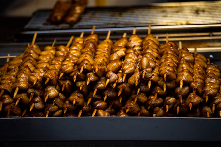 a large pile of grilled chicken butt skewers neatly arranged on a grillの写真素材