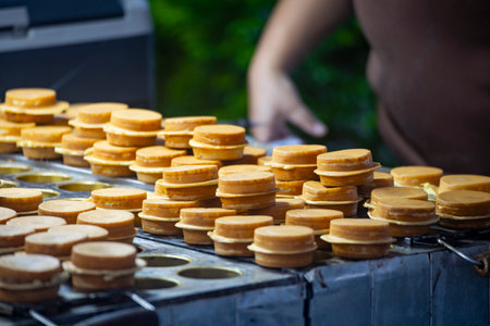 a vendor in the process of making hot and steaming wheel cakes