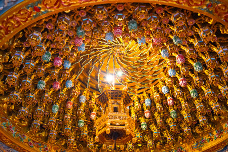 the ornate and complex ceiling structure known as the Caisson Ceiling (ZÇojÇng) in a traditional Asian templeの写真素材