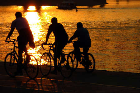 bicyclists on gold sunset river sava belgrade