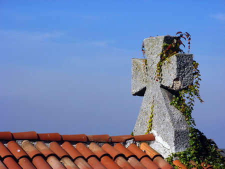 Stone cross and ivy onto the roof of the churchの写真素材