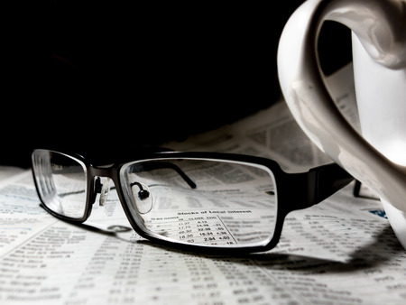 Newspaper with reading glasses and coffee cupの写真素材