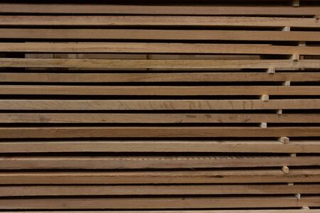 Background of a stack of wooden boards on storage lying horizontallyの写真素材