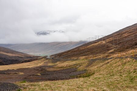 Scenic highway among mountains and hills, with a power lineの写真素材