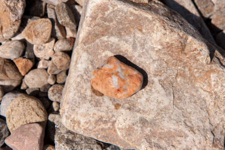 Rocks and pebbles on the shore in the water, various colorsの写真素材