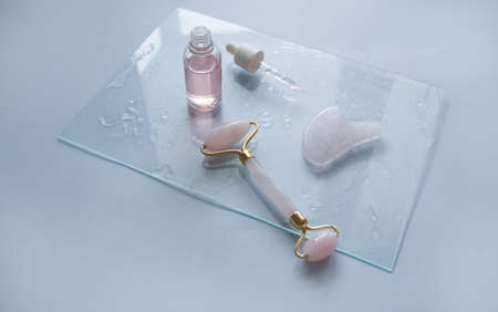 Facial massage attributes: Guasha scraper, cosmetic oil and facial rollerの写真素材