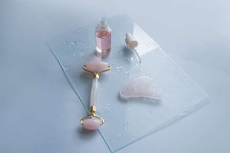 Facial massage attributes: Guasha scraper, cosmetic oil and facial rollerの写真素材