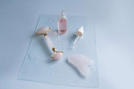 Facial massage attributes: Guasha scraper, cosmetic oil and facial roller