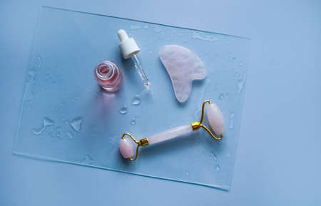Facial massage attributes: Guasha scraper, cosmetic oil and facial rollerの写真素材