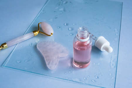 Facial massage attributes: Guasha scraper, cosmetic oil and facial rollerの写真素材