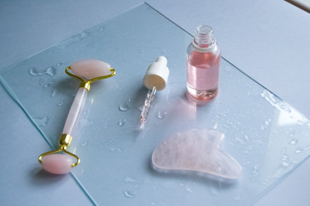 Facial massage attributes: Guasha scraper, cosmetic oil and facial rollerの写真素材