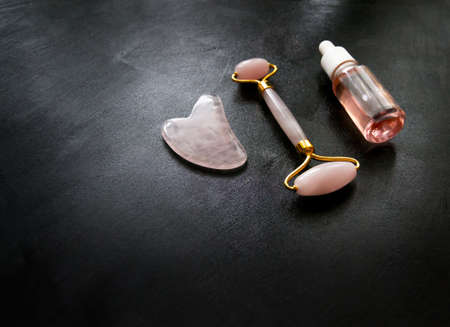 Facial massage attributes: Guasha scraper, cosmetic oil and facial rollerの写真素材