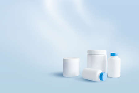 White empty sports nutrition containers on blue backgroundの写真素材